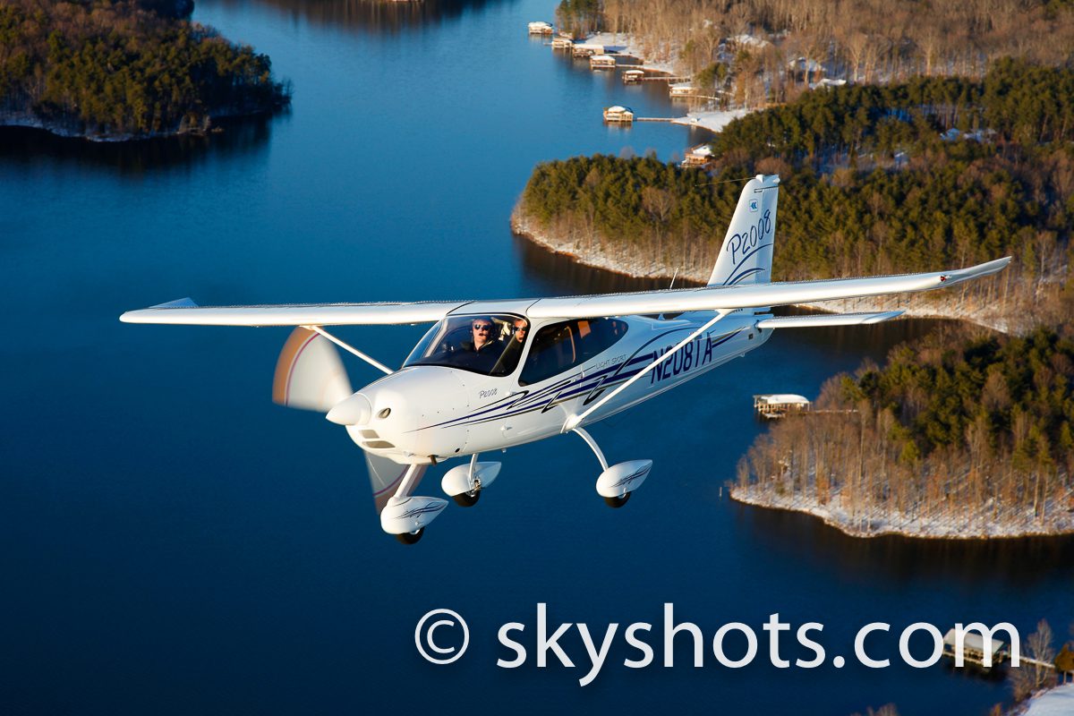 Light airplane cruising over wooded islands
